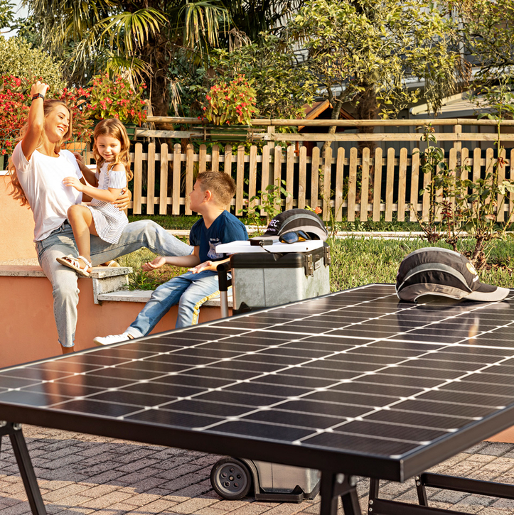 A smiling mother with her daughter and son and a single high-efficiency REC Alpha solar panel, happy with the reliability that comes with REC